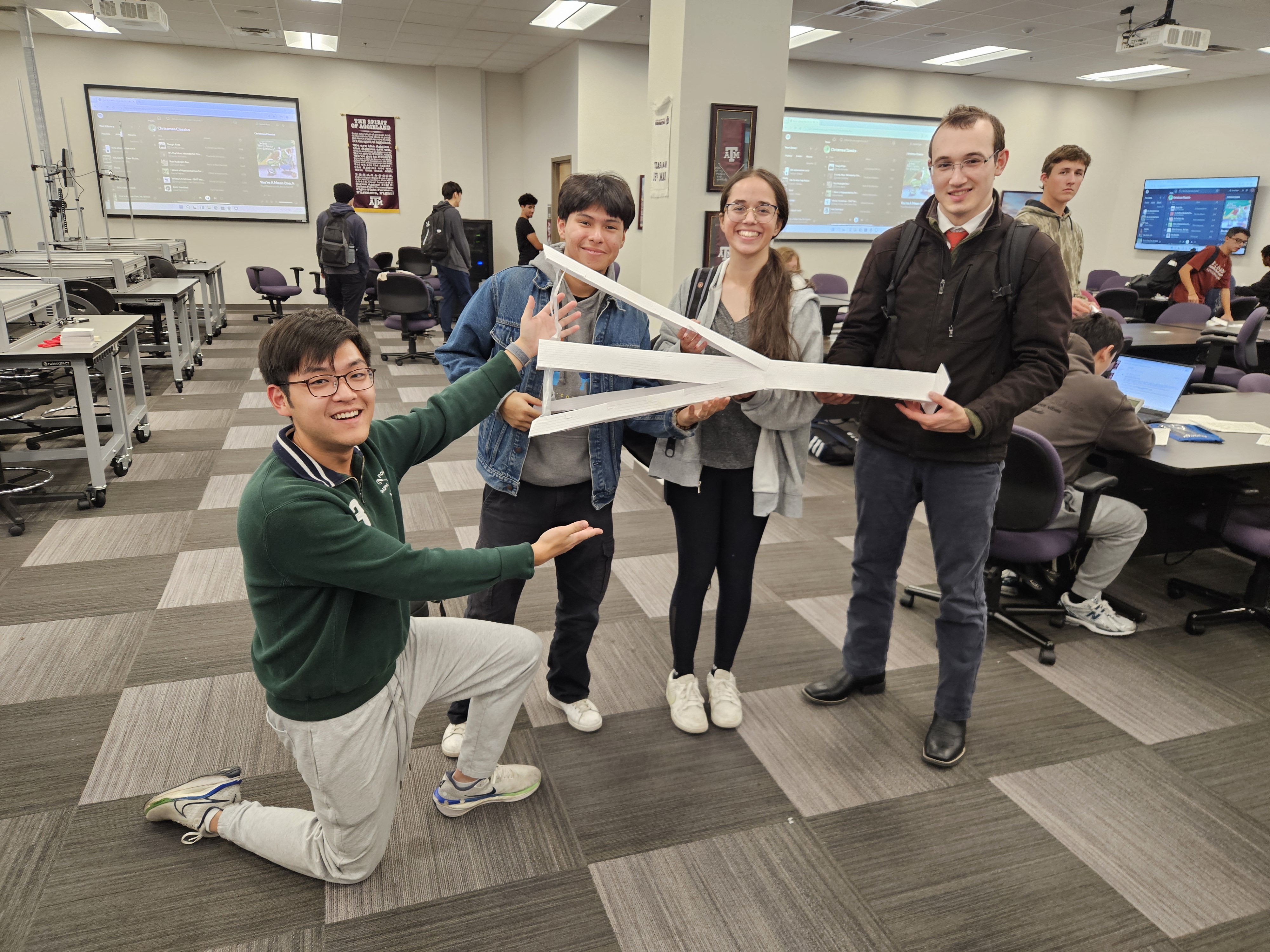 Team members holding house of cards sideways